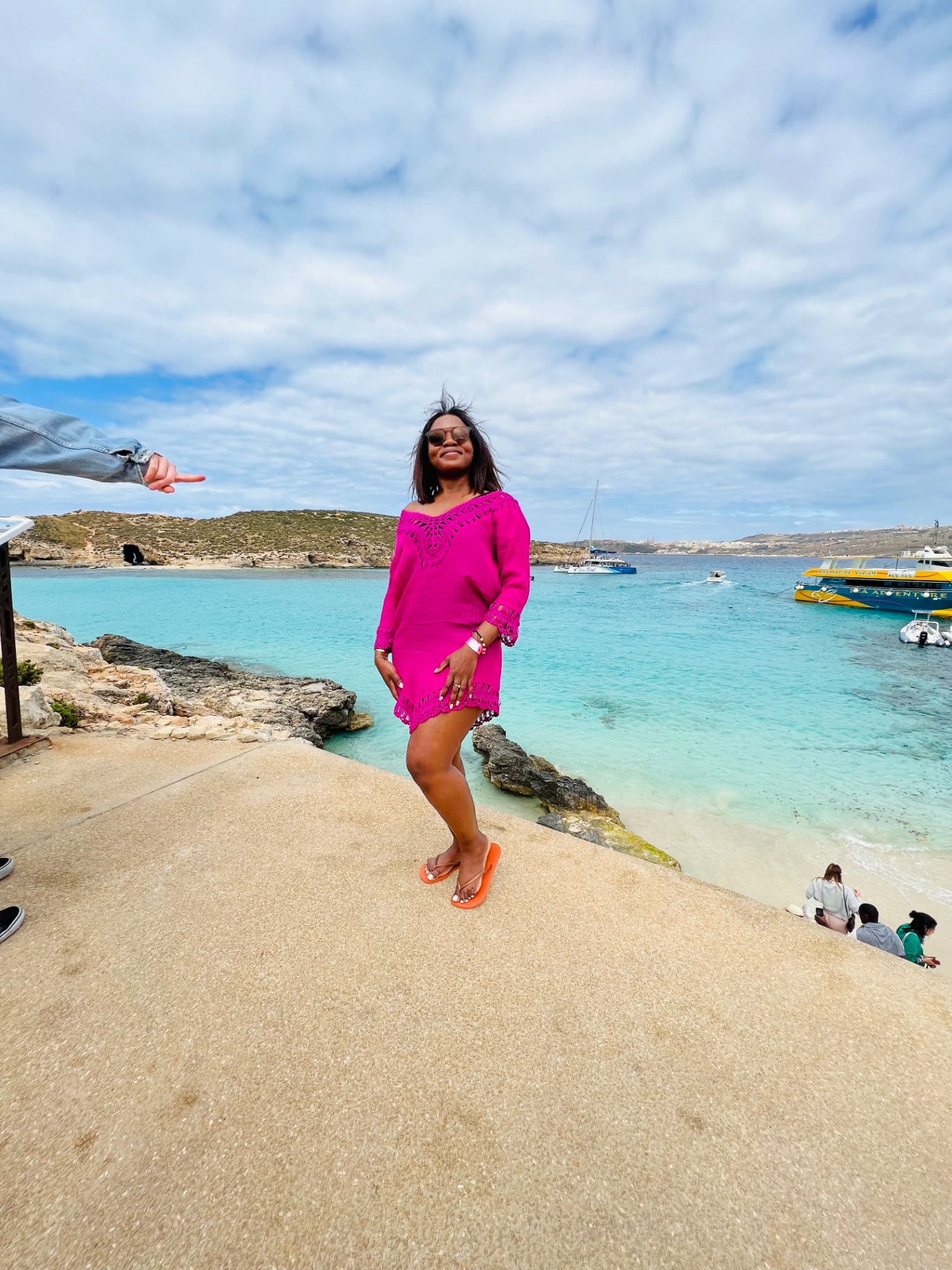 Une voyageuse en robe rose devant le Blue Lagoon