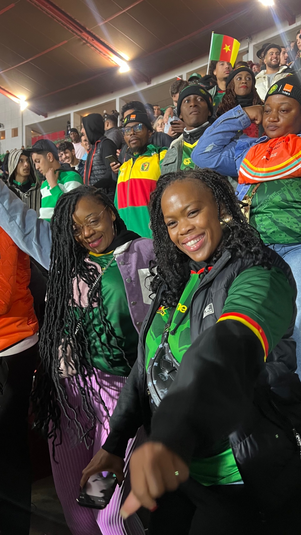 Cameroon supporters smiling together in the stadium