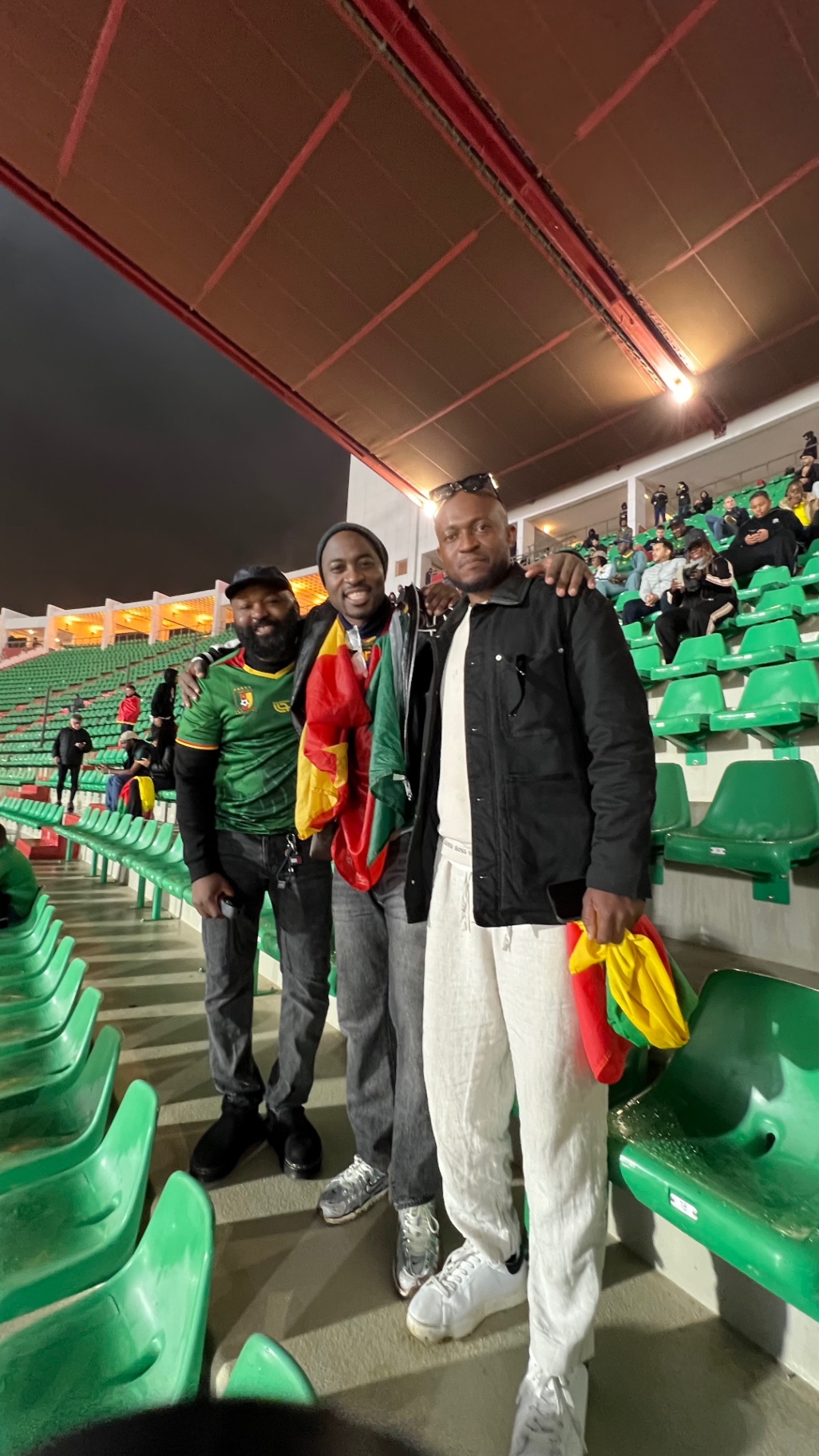 Three friends together in the stadium stands at night