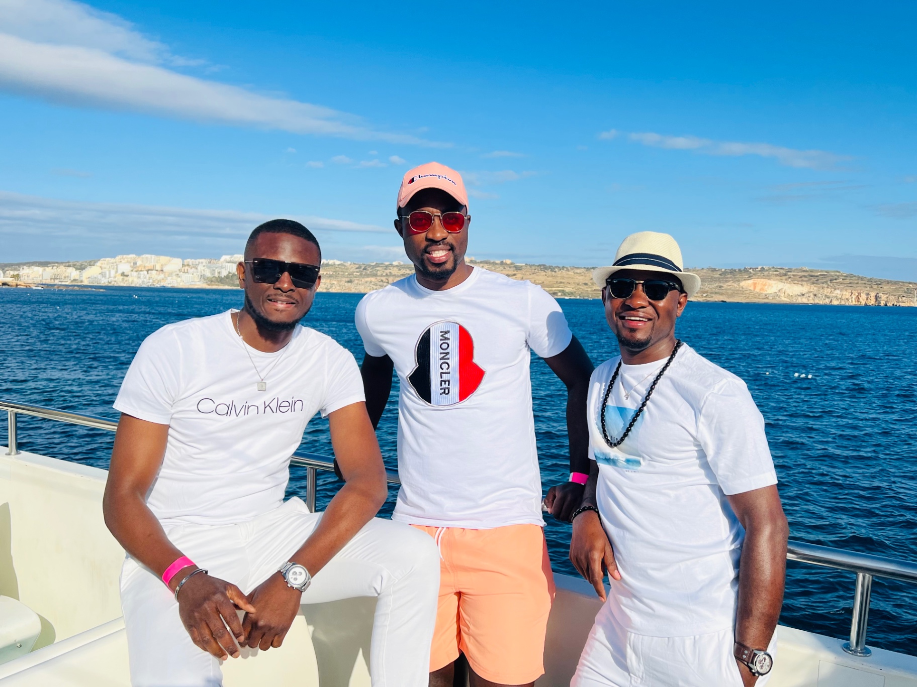 Trois amis en blanc posent sur un bateau à Malte
