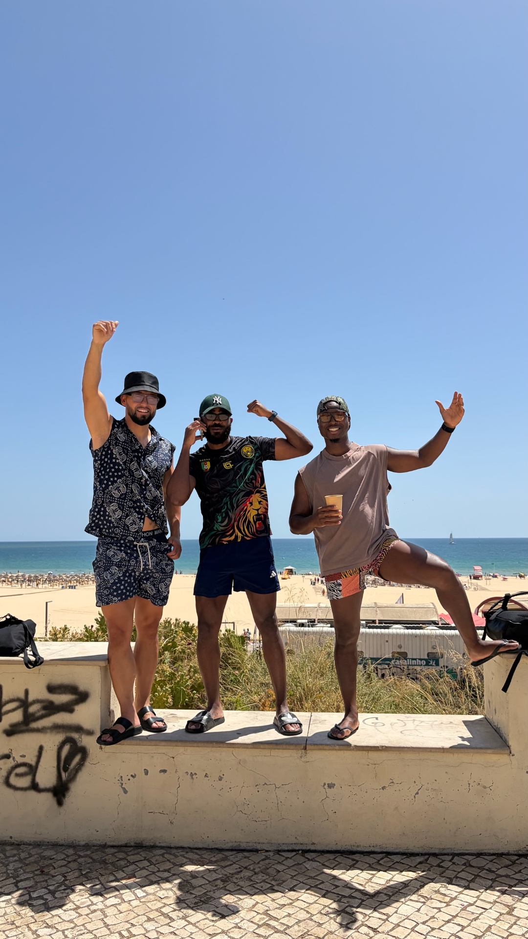 Three friends posing above the beach on a sunny day